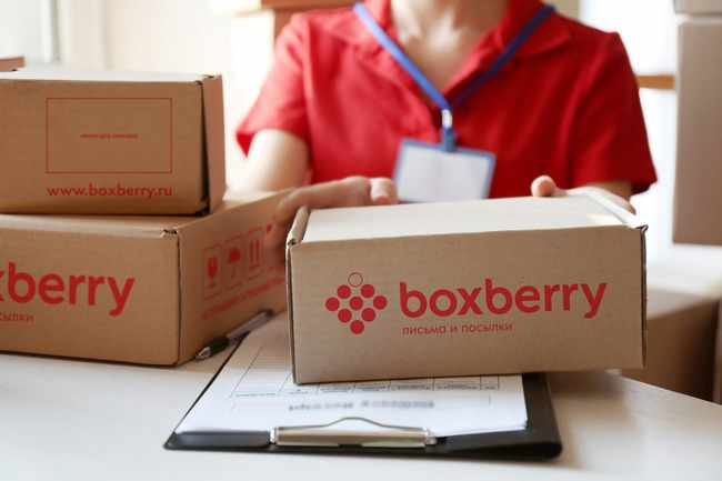 Сотрудница Boxberry с коробками