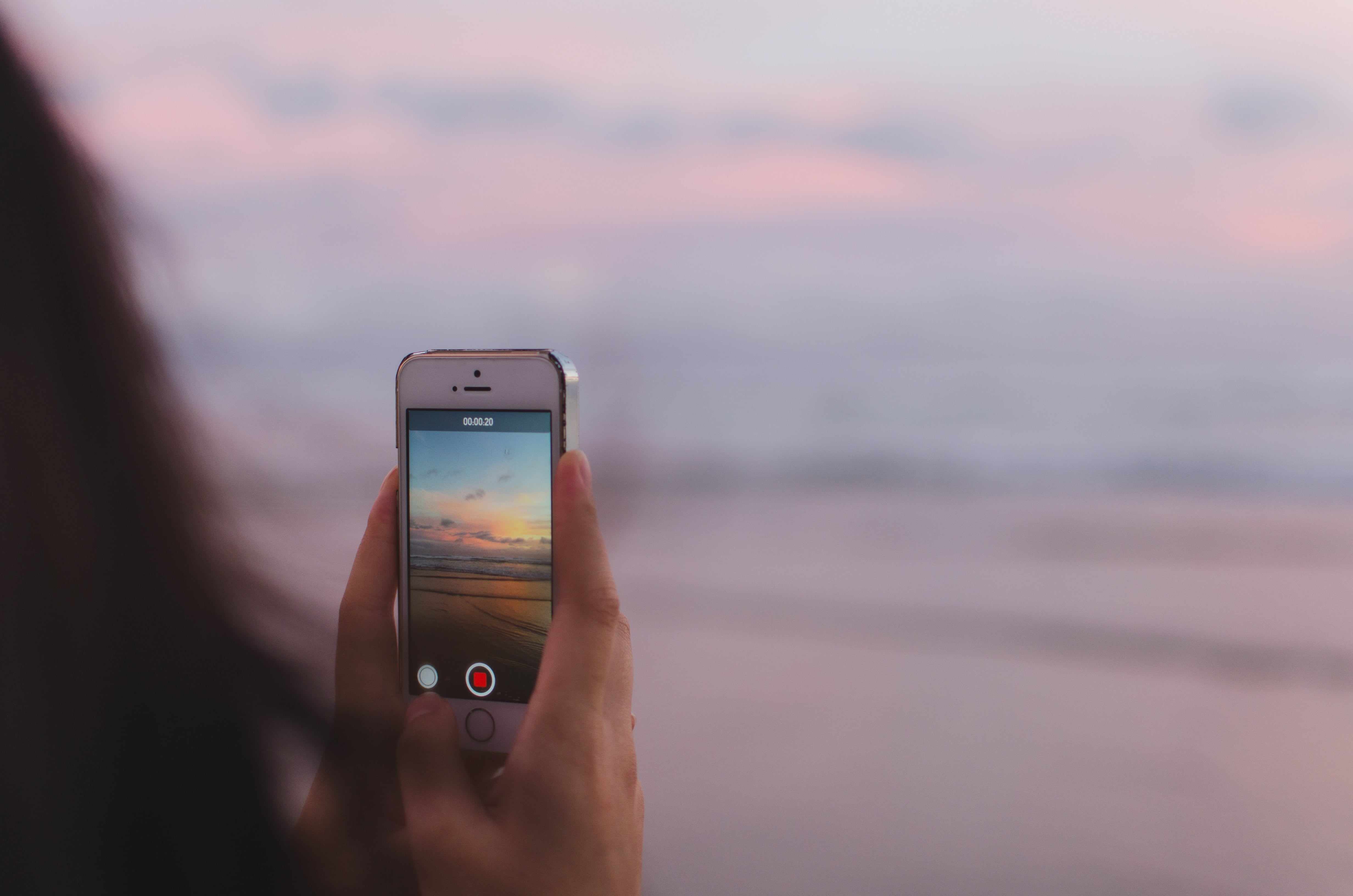 Девушка фотографирует пейзаж на телефон